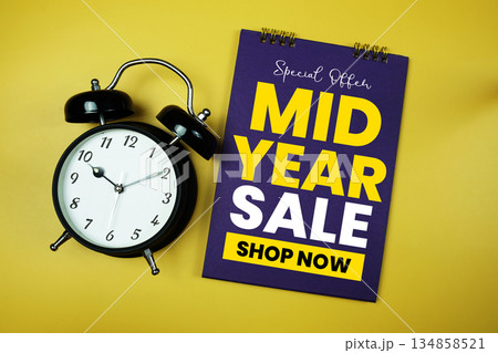 Mid Year Sale text with alarm clock on yellow background 134858521