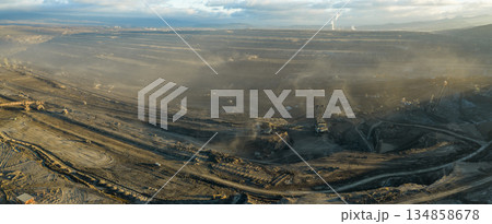 Aerial view of an active coal mining site showcases heavy machinery and smoke billowing into the air Aerial view of an active coal mining site showcases heavy machinery and smoke billowing into the air 134858678