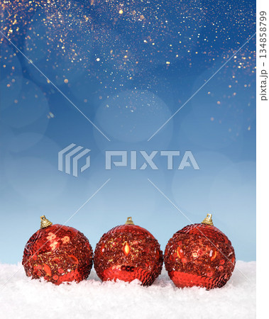 Christmas tree baubles on blue background with white snow and golden lights. Festive winter holiday background. Design with copy space for greeting card, text, advertising, banner, invitation Christmas tree baubles on blue background with white snow and golden lights. Festive winter holiday background. Design with copy space for greeting card, text, advertising, banner, invitation 134858799