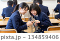スマートフォンを見て笑う2人の女子高校生 134859406