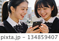 スマートフォンを見て笑う2人の女子高校生 134859407