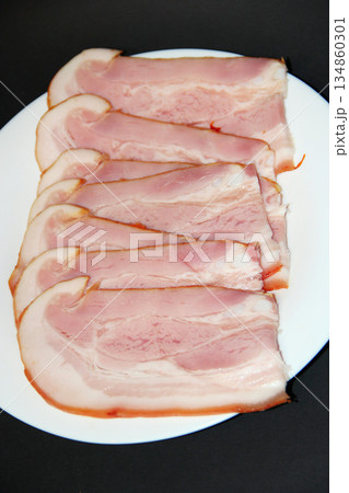 Sliced smoked meat on white plate. Food appetizer concept Sliced smoked meat on white plate. Food appetizer concept 134860301