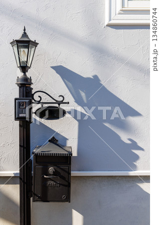 壁に映る影が印象的なアンティーク調の門柱と郵便ポスト 134860744