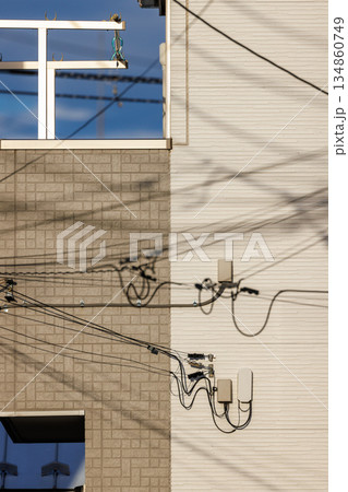 住宅の外壁に映る電線の影と通信設備の配線 住宅の外壁に映る電線の影と通信設備の配線 134860749