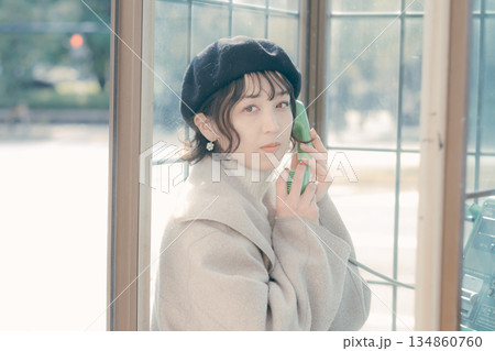公衆電話で通話する30代女性のライフスタイルシーン 公衆電話で通話する30代女性のライフスタイルシーン 134860760