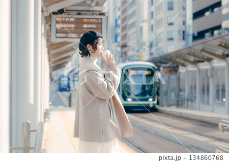 駅のホームでコーヒーを飲む30代女性のライフスタイルシーン 駅のホームでコーヒーを飲む30代女性のライフスタイルシーン 134860768