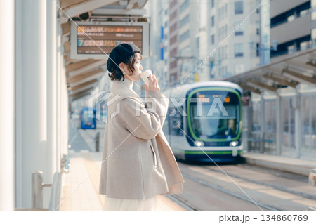 駅のホームでコーヒーを飲む30代女性のライフスタイルシーン 134860769