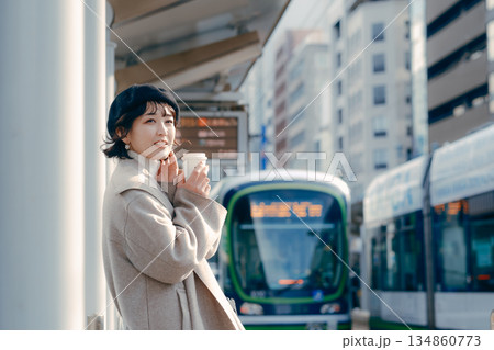 駅のホームでコーヒーを飲む30代女性のライフスタイルシーン 134860773