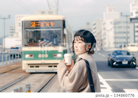 駅のホームでコーヒーを飲む30代女性のライフスタイルシーン 駅のホームでコーヒーを飲む30代女性のライフスタイルシーン 134860776