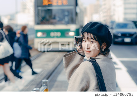カメラを構えて笑顔を見せる30代女性のポートレート カメラを構えて笑顔を見せる30代女性のポートレート 134860783