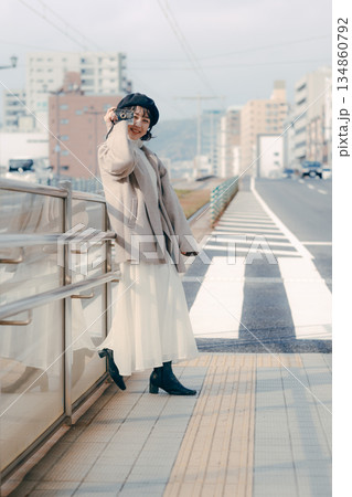 カメラを構えて笑顔を見せる30代女性のポートレート 134860792