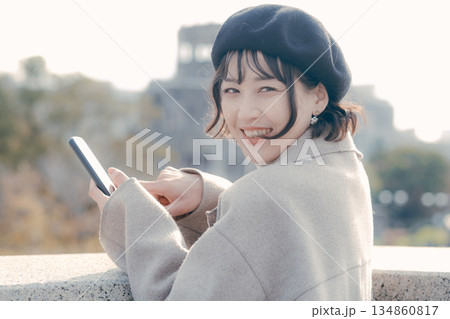 観光地でスマートフォンを操作して情報を調べる30代女性 観光地でスマートフォンを操作して情報を調べる30代女性 134860817