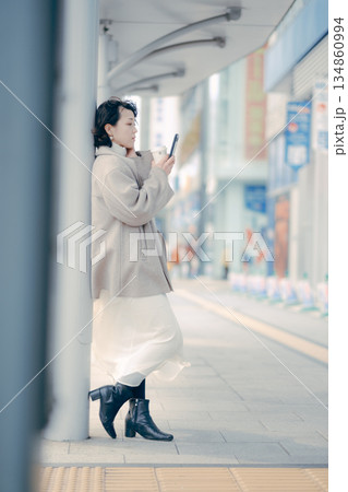 バス停でスマートフォンを操作しながら待つ30代女性 134860994