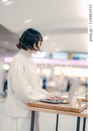 街中でノートパソコンを操作する30代女性 街中でノートパソコンを操作する30代女性 134861015