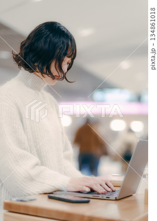 街中でノートパソコンを操作する30代女性 134861018
