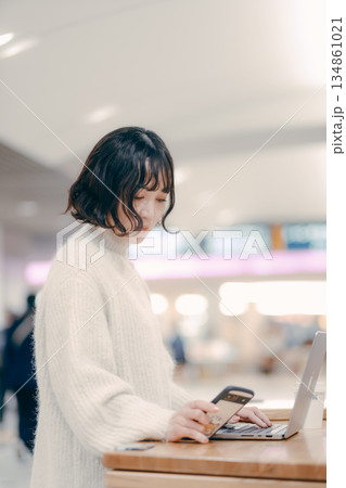 街中でノートパソコンを操作する30代女性 134861021