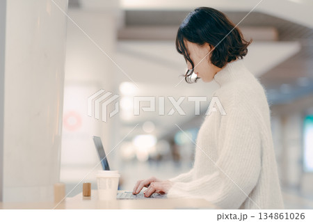街中でノートパソコンを操作する30代女性 街中でノートパソコンを操作する30代女性 134861026
