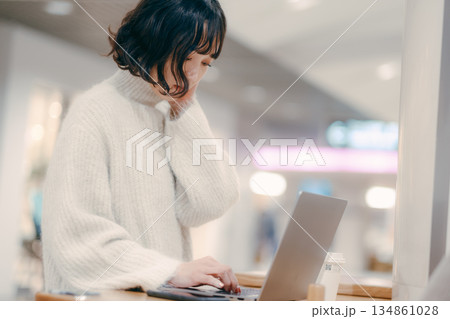 街中でノートパソコンを操作する30代女性 街中でノートパソコンを操作する30代女性 134861028