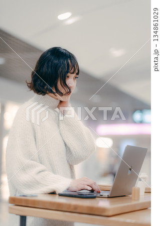 街中でノートパソコンを操作する30代女性 134861029