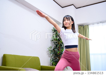 戦士のポーズ2 自宅で柔軟、ヨガをする若い女性 ヨガウェア 戦士のポーズ2 自宅で柔軟、ヨガをする若い女性 ヨガウェア 134861513