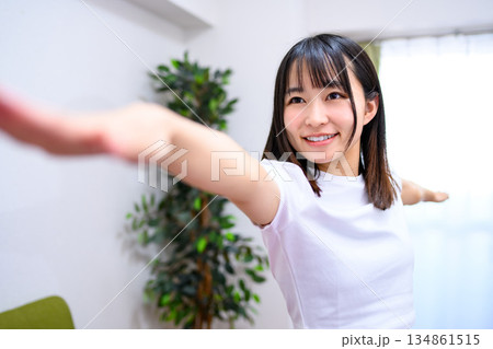 戦士のポーズ2 自宅で柔軟、ヨガをする若い女性 ヨガウェア 戦士のポーズ2 自宅で柔軟、ヨガをする若い女性 ヨガウェア 134861515