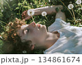 young boy lying on dandelion flower 134861674