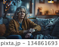 unhappy older woman sitting alone on a sofa 134861693