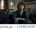 unhappy older woman sitting alone on a sofa 134861695