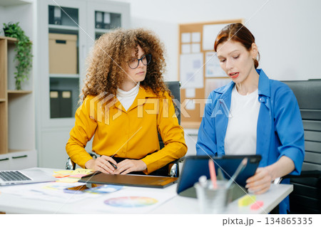 UX UI designers in modern office working on app wireframes, color palettes, and digital tools. Creative teamwork, planning, technology 134865335