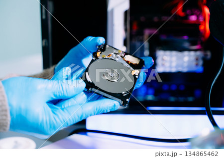 Hard disk drive on the technician's desk and a computer motherboard as a component. the concept of data, hardware, and information technology. 134865462