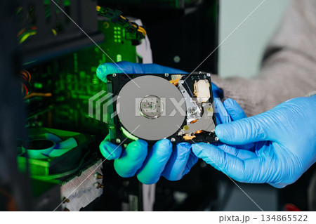 Hard disk drive on the technician's desk and a computer motherboard as a component. the concept of data, hardware 134865522