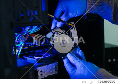 Hard disk drive on the technician's desk and a computer motherboard as a component. the concept of data, hardware 134865535