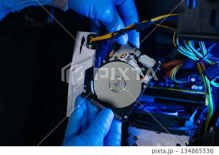 Hard disk drive on the technician's desk and a computer motherboard as a component. the concept of data, hardware Hard disk drive on the technician's desk and a computer motherboard as a component. the concept of data, hardware 134865536