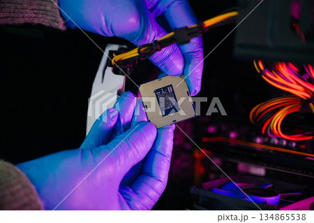 The technician is putting the CPU on the socket of the computer motherboard. electronic engineering electronic repair, electronics measuring 134865538