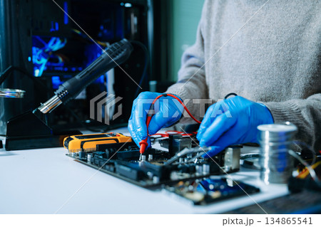 Electronics technician, electronic engineering electronic repair, electronics measuring and testing, repair and maintenance concepts.uses a voltage meter to check 134865541