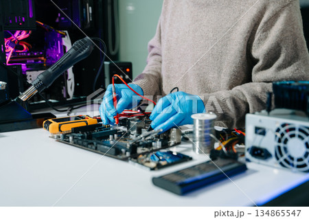 Electronics technician, electronic engineering electronic repair, electronics measuring and testing, repair and maintenance concepts.uses a voltage meter to check and upgrade Electronics technician, electronic engineering electronic repair, electronics measuring and testing, repair and maintenance concepts.uses a voltage meter to check and upgrade 134865547