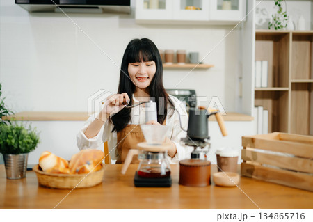 Young female entrepreneur hanging a welcome sign in front of a coffee shop. Beautiful waitress 134865716