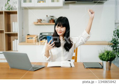 Cheerful businesswoman checking time feeling motivated waiting for leaving office do on their tablet, laptop Cheerful businesswoman checking time feeling motivated waiting for leaving office do on their tablet, laptop 134865842