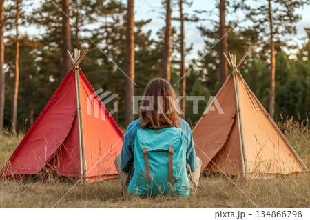 Serene Solo Camper Gazing at Clear Summer Sky in Nature with Colorful Tents 134866798