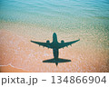 Airplane Shadow Over Sand and Water at Exotic Travel Destination Concept 134866904