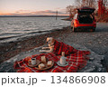 Cozy Picnic Scene by the Trunk of a Car During Golden Hour at the Lake 134866908