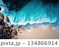 Mesmerizing Top Down Perspective of Foamy Turquoise Waves Against Sandy Shoreline 134866914