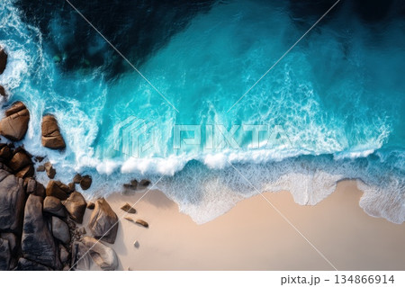 Mesmerizing Top Down Perspective of Foamy Turquoise Waves Against Sandy Shoreline 134866914