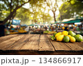 Rustic Wooden Table in Foreground with Fresh Lemons on Bright Market Background 134866917
