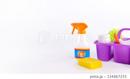Cleaning supplies arranged on a white background, featuring a spray bottle, sponge, and purple caddy, illustrating effective cleaning solutions Cleaning supplies arranged on a white background, featuring a spray bottle, sponge, and purple caddy, illustrating effective cleaning solutions 134867255