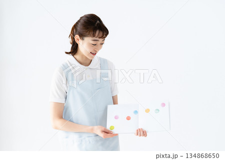 絵本を持つ保育士の女性 134868650