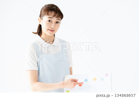 絵本を持つ保育士の女性 134868657