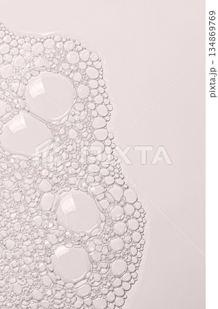 The texture of the foam of shower gel or soap suds or shaving foam. Macrophotography. Copy space 134869769