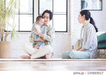 リビングで赤ちゃんを抱く夫婦 リビングで赤ちゃんを抱く夫婦 134869917