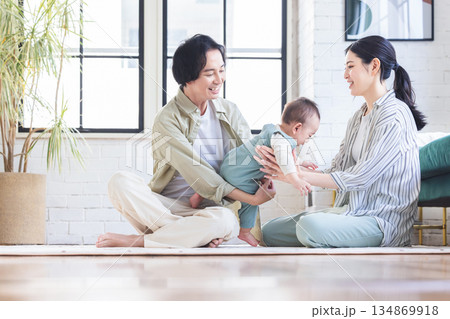 リビングで赤ちゃんを抱く夫婦 リビングで赤ちゃんを抱く夫婦 134869918